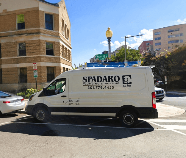 White plumbing van parked on street corner. White plumbing van parked on street corner.